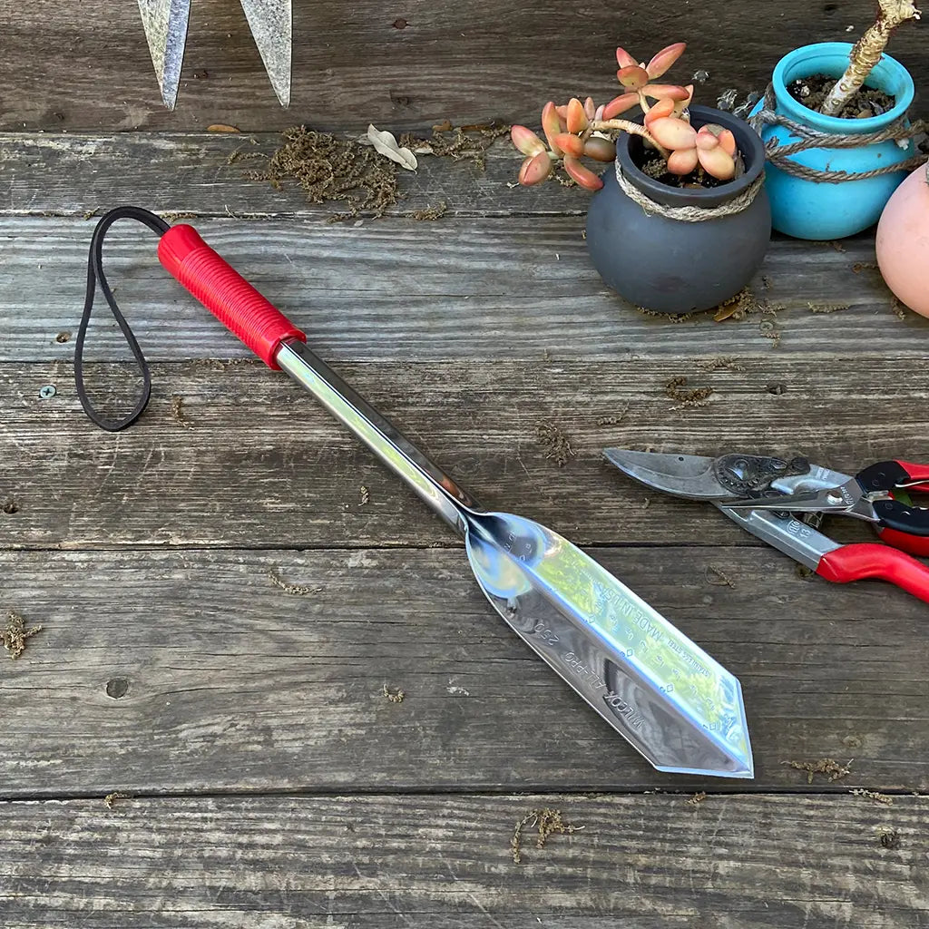 Long Handle Digging Trowel by Wilcox on garden table
